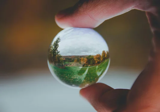 Boule de verre tenue dans les mains pour apercevoir l'avenir.