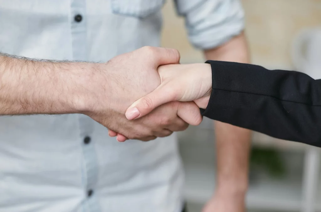 Deux personnes se serrant la main pour se féliciter de la séance de coaching réalisée.